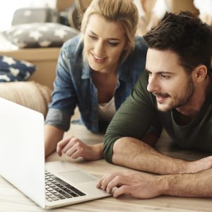 Young couple in new flat using laptop